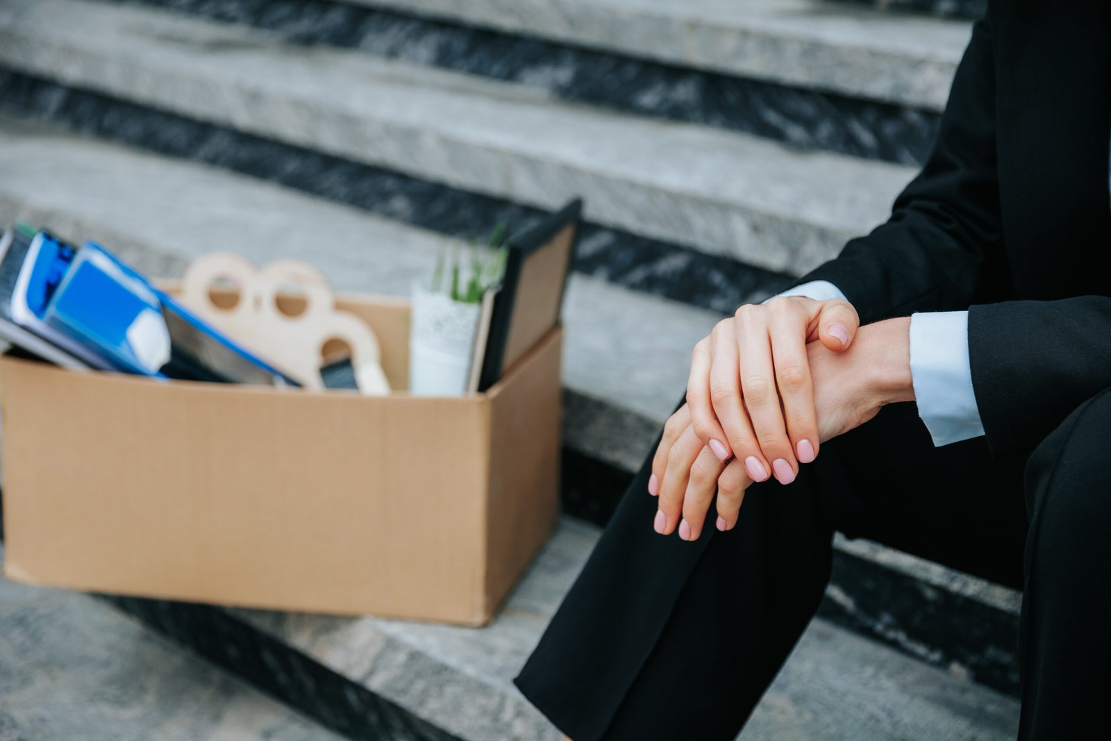 The devastating impact of the recession on people's lives - a pair of hands holding a carton box. Packing Up The Emotional Toll of Unemployment in a Carton Box